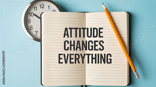 Attitude changes everything concept with notebook, pencil, and clock on a bright desk