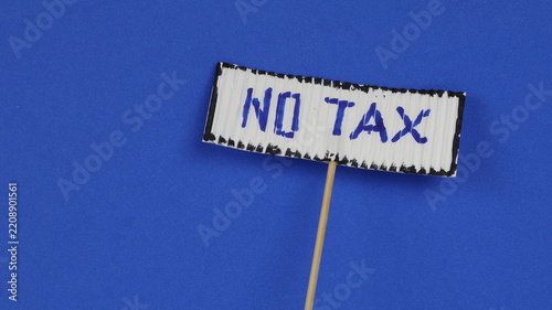 NO TAX Protest placard with white lettering on a blue background. Studio shot of the handwritten text