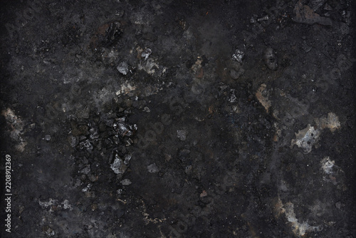 A horizontal top view full frame texture background of dark black soot charcoal and burnt ash remnants.
