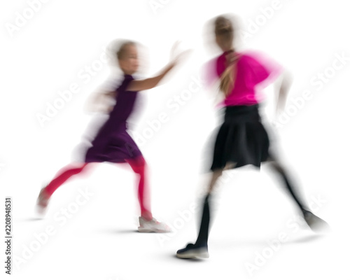 Motion blur image of two girls playing and running isolated on white and transparent background