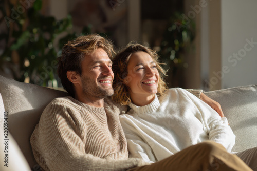 Happy couple relaxing on sofa, enjoying time together at home