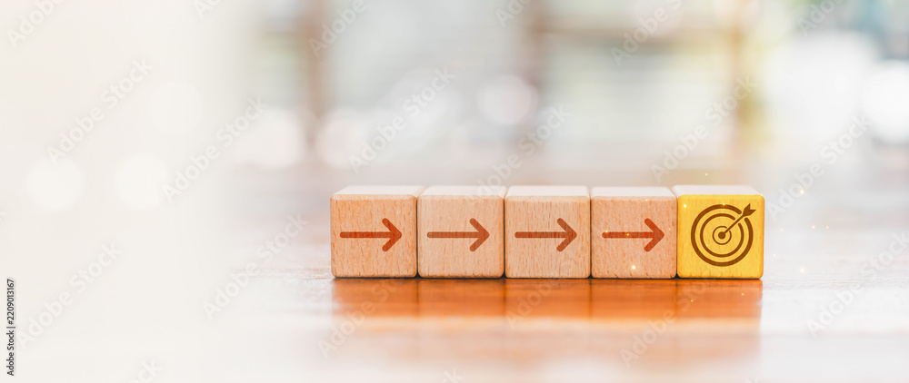 Fototapeta premium Wooden blocks form a step by step path toward a target, symbolizing business strategy, planning, progress, goal setting, focus, achievement, success, growth, direction, and strategic execution.