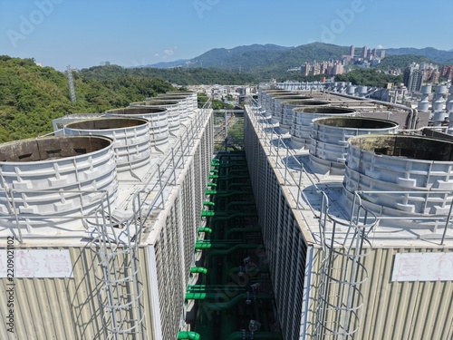 Industrial cooling towers array on rooftop of modern data center building.