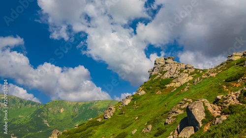 green mount slope under cumulus clouds time lapse scene