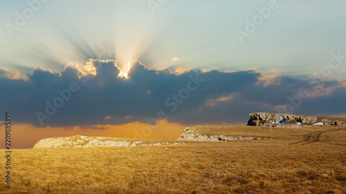 grass hill with melting snow at the sunset, spring outdoor evening time lapse scene