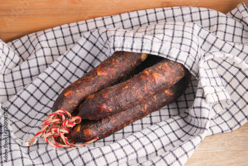 Several pieces of smoked pork and beef sausages tied together 