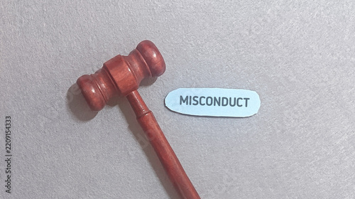 Misconduct legal concept with wooden gavel and blue label on textured grey background
