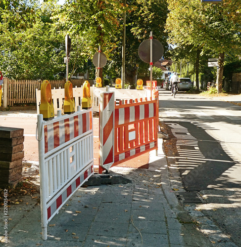 road closed for work with red and white barrage, warning lights and stop signal