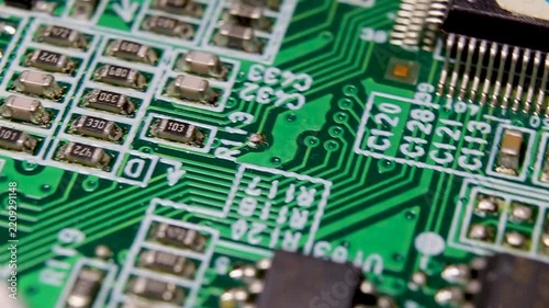 Part of an electronic printed circuit board with electronic components and connections, video macro shooting