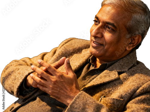 Distinguished Indian professional, silver hair, warm smile, brown textured blazer, hands clasped, isolated on transparent background