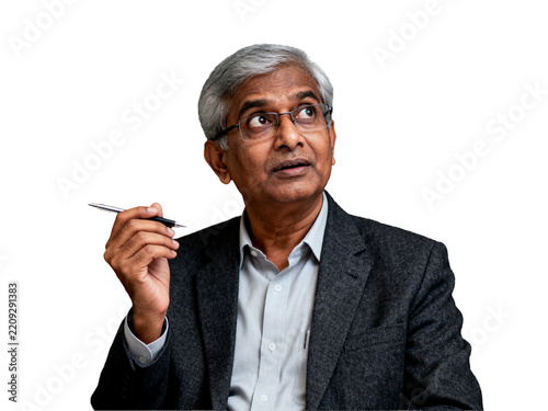 Gray-haired Indian professional, isolated transparent background, in a textured charcoal blazer holding a pen, exhibiting a pensive upward gaze