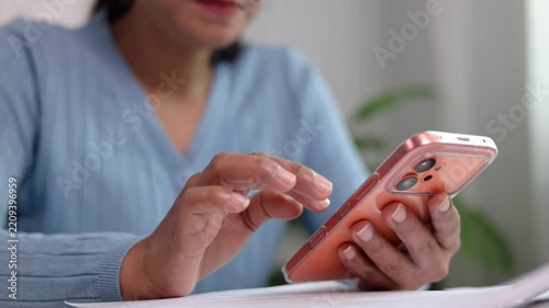 Female designer operating portable touchscreen device with digital stylus pen at work table reviewing creative project graphics in bright contemporary studio workplace room