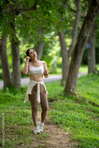 Peaceful young woman enjoying a walk in a lush green park during daytime