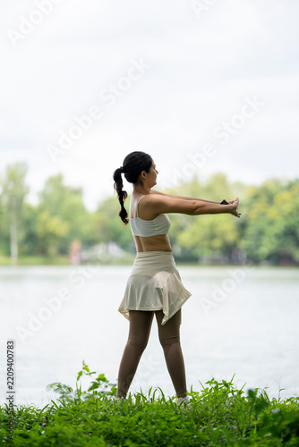 Woman Practicing Yoga Outdoors by Lake in Sportswear During Daylight