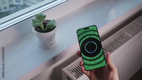 POV of holding smartphone using AI voice assistant to diagnose houseplant