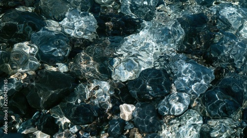 Close-up of a group of small rocks and pebbles. the rocks are of different sizes and shapes, with some being black and others being silver.