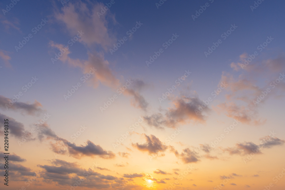 Fototapeta premium Pastel Sunset Sky Background with Soft Golden Clouds,A serene sunset sky background featuring soft pastel purple tones and gentle golden clouds. Ideal for nature, background, travel, and inspiring cop