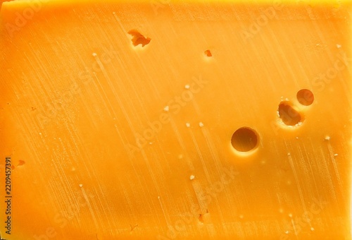 Obraz na plátně Orange cheddar cheese texture background, full frame hard cheese with holes