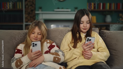 Siblings scroll social media on phones, showing excessive gadget use