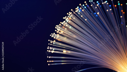 Fiber optic strands abstract light glowing thread dark background curved line luminous tip blue tone orange glow technology data network optical fiber light trail transparent strand fiber optic