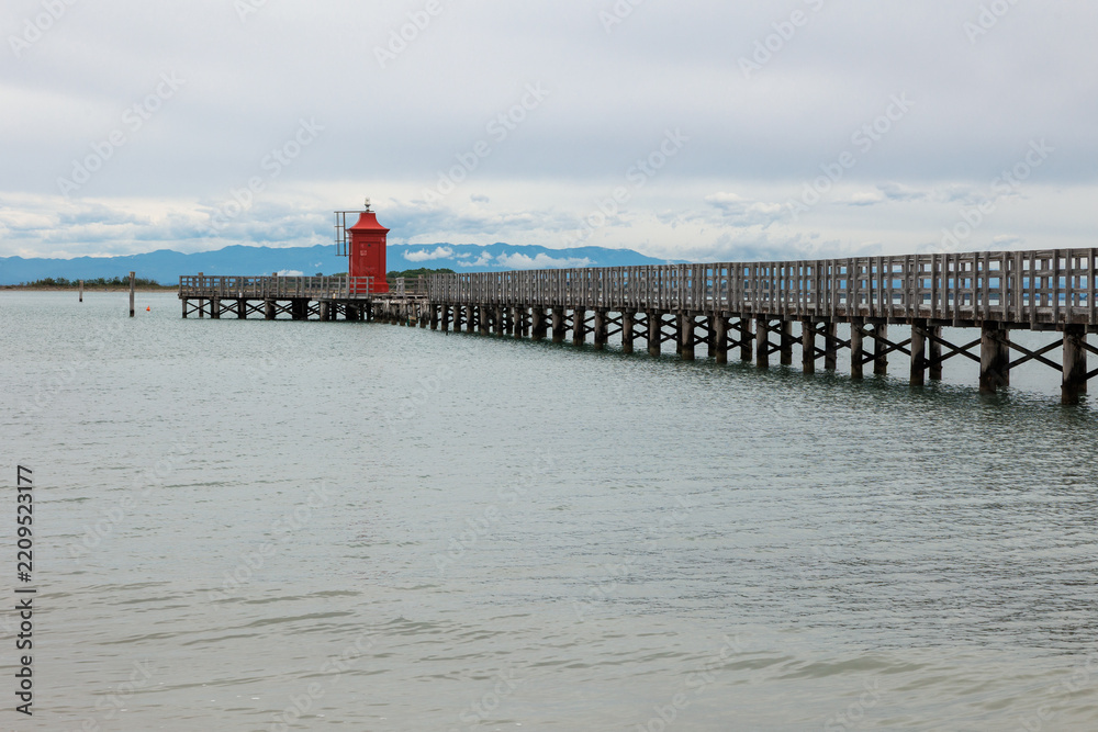 Fototapeta premium 14 Ponte di legno con Faro rosso a Lignano Sabbiadoro Italia
