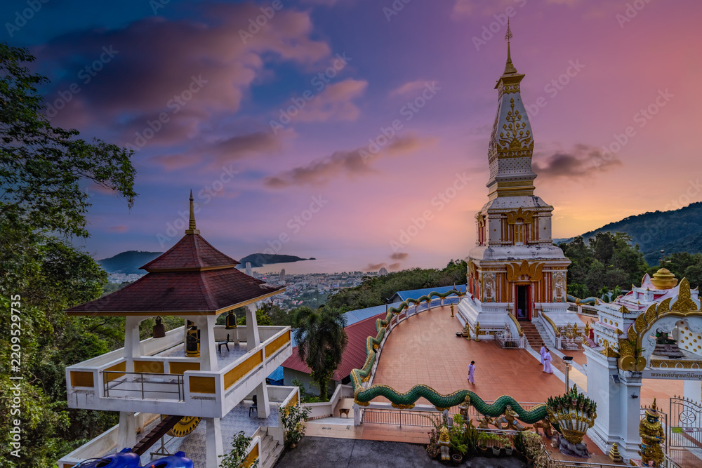 Fototapeta premium Golden Sunset Over a Beautiful Buddhist Temple on Patong Mountain, Phuket, Thailand, Surrounded by Tropical Hills and Dramatic Evening Skies Pa Tong Phuket island Thailand