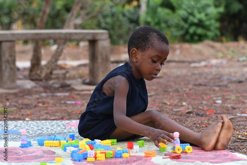 Little girl on the floor at home playing with building bricks