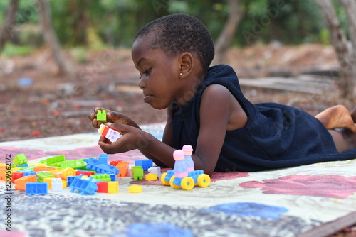 Little girl on the floor at home playing with building bricks
