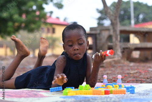 Little girl on the floor at home playing with building bricks