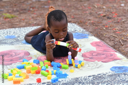 Little girl on the floor at home playing with building bricks