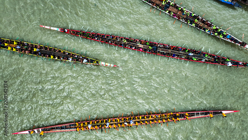 Baghabari, Rajshahi Division, Bangladesh - 20 August 2022: Aerial view of long racing boats filled with rowers competing on the river, showcasing synchronized paddling.