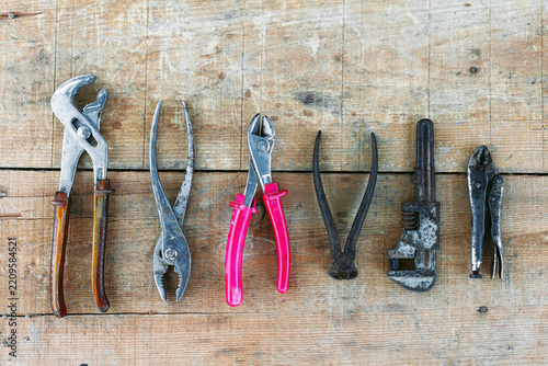 Worn hand tools arranged on rustic wooden workbench