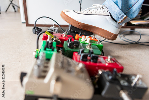 Musician using guitar effect pedalboard in studio