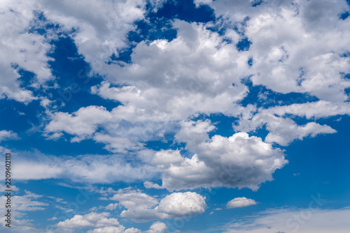 White fluffy clouds forming in clear blue sky