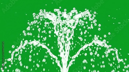 Crystal clear water fountain splashing droplets upward against vibrant green screen background in motion video footage