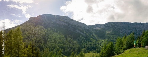 Scenic Limestone Mountain Ridge above Lush Alpine Forest and Sunlit Meadow in Rax Alps Austria