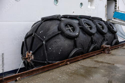 Large Black Marine Rubber Fender Secured Along a Vessel at the Dock