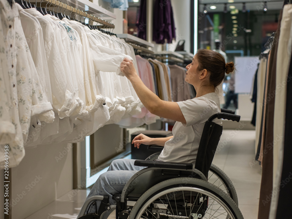 Obraz premium A Caucasian woman in a wheelchair shopping at a mall. 