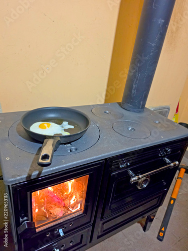 A wood-burning stove burning in the kitchen.
