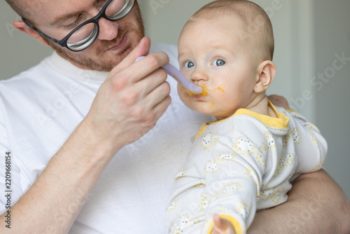 Father feeding his baby. Child likes to eat tasty baby food