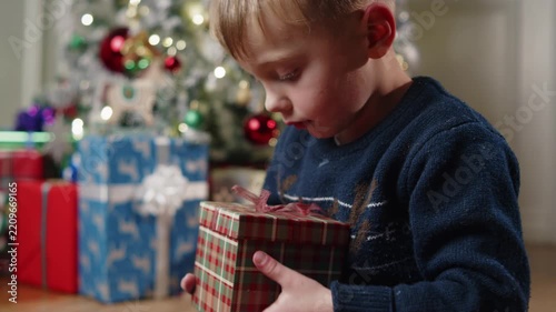 Joyful moments of a child opening a Christmas gift with wonder