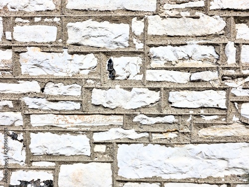 Obraz na plátně Close-up of a rustic exterior stone wall featuring light-colored ashlar blocks set with distinct dark mortar lines