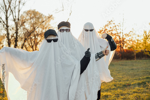People wearing ghost costumes in outdoor setting