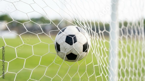 Soccer ball in goal net. Football sport background with blurred field