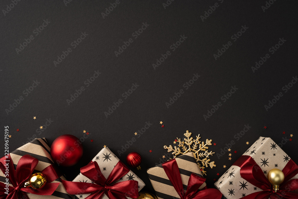Obraz premium Elegant Christmas gifts with red ribbons and gold ornaments on a black background for holiday greeting