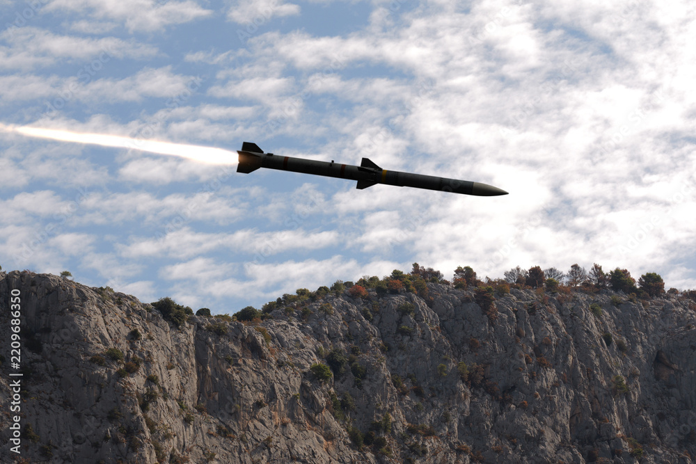 Fototapeta premium Guided missile flying above rocky cliffs under a cloudy sky