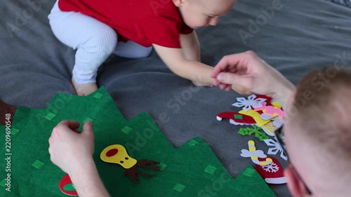 Father and his son decorating toy Christmas tree together. Educational games for children. 4K