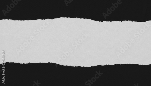 Horizontal strip of torn white paper on a black background, with irregular rough edges, subtle texture and ample central copy space for text or design.