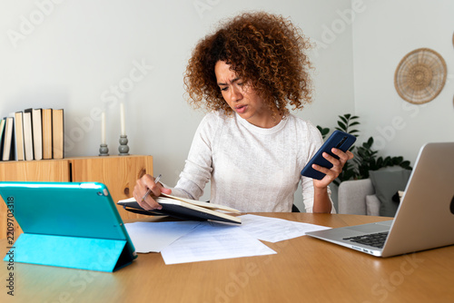 Stressed woman multitasking working remotely at home office