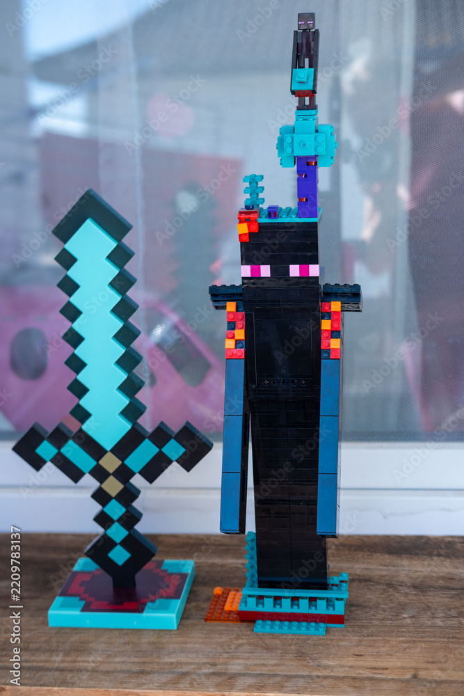 Obraz premium LEGO Minecraft Enderman figure tall black creature diamond sword built colorful blocks display wooden table background gaming merchandise collectible toy model construction, Childhood play creativity